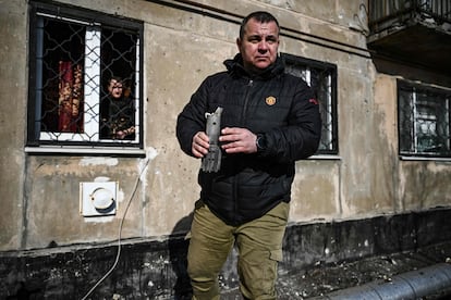 Un hombre sujeta lo que queda de un mortero que explotó frente a un edificio de viviendas en Schastia, cerca de la ciudad ucrania de Lugansk, este martes.