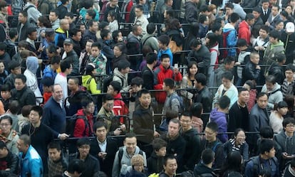 Ciudadanos chinos guardan fila ante una nueva tienda Apple.