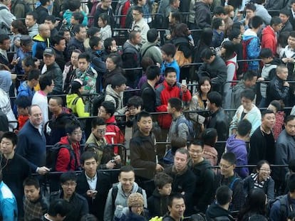 Ciudadanos chinos guardan fila ante una nueva tienda Apple.