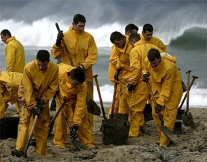 Infantes de Marina limpian con palas la playa de Barañán, en el municipio de Arteixo.