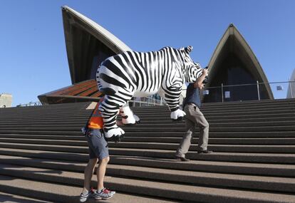 Unos trabajadores transportan una escultura de un rinoceronte por las escaleras de la Casa de la ?pera en Sydney (Australia).