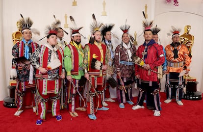 Un grupo de bailarines y cantantes nativos americanos del pueblo Osage, con su indumentaria ceremonial, a su llegada a la alfombra roja.