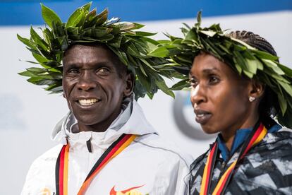 Eliud Kipchoge (c) y Gladys Cherono, en el podio después de la ceremonia de entrega de premios.