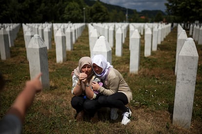 Dos mujeres lloran junto a la tumba de su familiar, víctima del Genocidio de Srebrenica, antes de la ceremonia de entierro en Potocari, Bosnia.