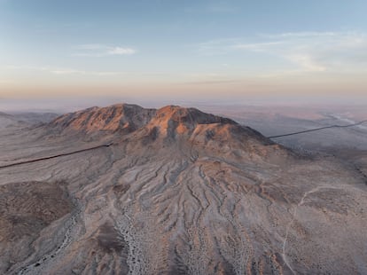 Atardece en el desierto. La tenue luz ilumina una montaña que provoca una intermitencia en el muro, cerca de la localidad mexicana de Mexicali (Baja California).