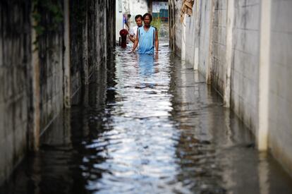 Dos hombres tratan de avanzar en un callejón inundado en el centro de Bangkok