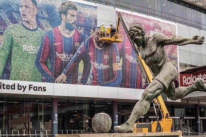 Operarios retiran a Messi de la facha del Camp Nou.