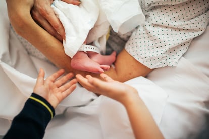 Un recién nacido en brazos de su madre en un hospital.