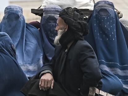 Un afgano viaja en un vehículo en compañía de varias mujeres con burka por una carretera de Mazar-i. Sharif, el 21 de diciembre de 2021.