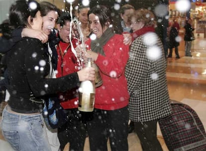 Algunos de los afortunados con el tercer premio, vendido íntegramente en Asturias, lo celebran delante de la administración número 32 de Oviedo, situada en el Centro Comercial Los Prados.