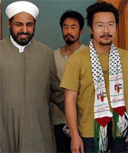 Dos japoneses liberados, junto a un  clérigo iraquí, ayer en Bagdad.