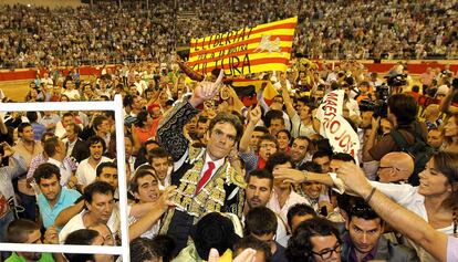 Los toreros José Tomás (en primer término) y Serafín Marín, salen a hombros tras la última corrida de toros celebrada en la plaza Monumental de Barcelona.