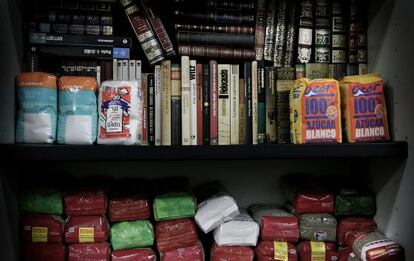 Los libros dejan paso a la comida en los estantes de la biblioteca de la Asociación de Vecinos de Benicalap.