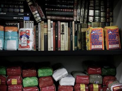 Los libros dejan paso a la comida en los estantes de la biblioteca de la Asociación de Vecinos de Benicalap.