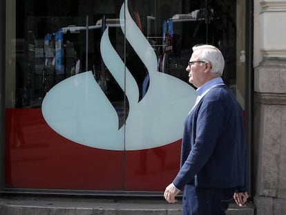 Un hombre pasando por delante de una oficina de Banco Santander