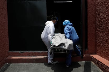 Trabajadores de una funeraria transportan un cuerpo al crematorio en Ciudad de México este lunes.