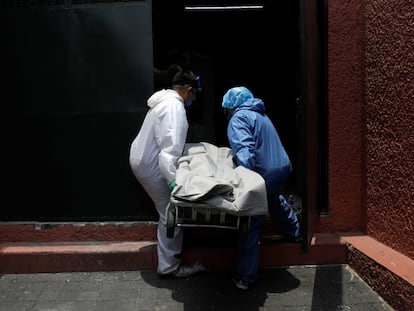 Trabajadores de una funeraria transportan un cuerpo al crematorio en Ciudad de México este lunes.