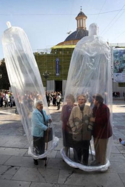 Mujeres enfundadas en dos preservativos gigantes celebran el Día Mundial del Sida, en la Plaza de la Virgen (Valencia)