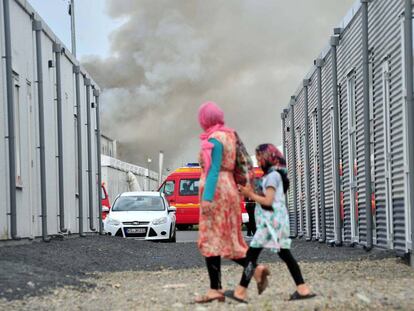 Dos refugiadas caminan frente a un centro de acogida de asilados en Kassel (Alemania) donde se produjo un incendio accidental este domingo.