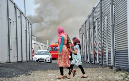 Dos refugiadas caminan frente a un centro de acogida de asilados en Kassel (Alemania) donde se produjo un incendio accidental este domingo.