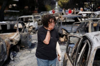 Una dona plora mentre intenta trobar el seu gos, perdut durant l'incendi a Mati (Grècia).