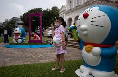 Una niña posa junto con una figura de Doraemon durante la exposición celebrada en el Museo Nacional de Singapur este martes con motivo del 50º aniversario de este personaje animado japonés.