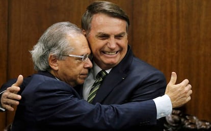 Paulo Guedes abraça Bolsonaro. 