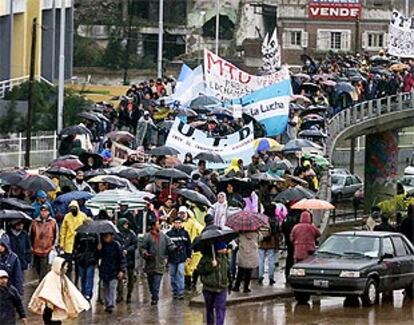 Miles de argentinos se manifestaron ayer bajo la lluvia para protestar por la represión policial que costó la vida a dos personas.