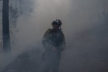El municipio de Ribas de Sil quedó completamente cubierto por el humo de los distintos fuegos. La humareda envuelve a uno de los bomberos forestales que participan en el control del incendio