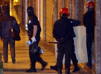 Varios agentes de la Ertzaintza salen de un piso en Hernani, donde se han llevado a cabo los registros.