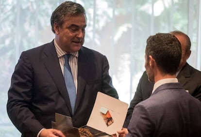 El embajador de España en Venezuela recibe un obsequio de sus compañeros durante una reunión.