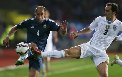 Pablo Zabaleta disputa el balón con Godín.