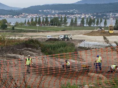 Operarios trabajan en la construcción del vial, con los restos arqueológicos a la vista a la izquierda de la imagen.