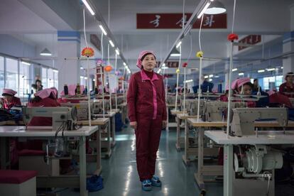 Una mujer posa entre las máquinas de coser en unas instalaciones descritas como la fábrica del bolso de Pyongyang.