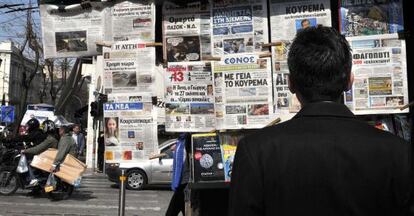 Un hombre lee los titulares de la prensa la mañana del viernes en Atenas.