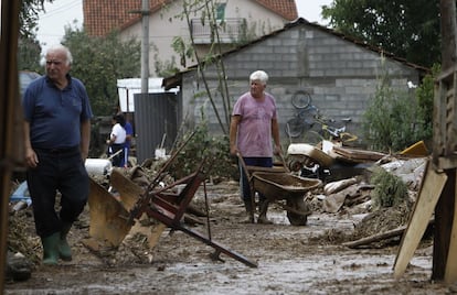 Un hombre lleva un carro con barro extraído de su casa inundada después de la tormenta, que provocó inundaciones de hasta 1,5 metros y deslizamientos de terreno.