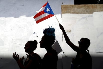 Un grupo de mujeres levanta una bandera durante la huelga de este lunes en San Juan.