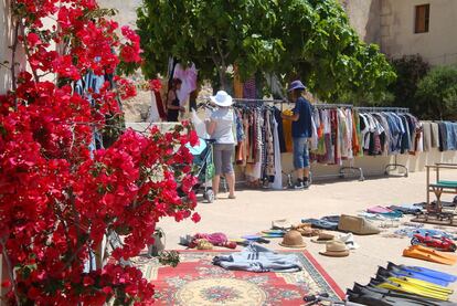 Los sábados por la mañana, un mercadillo de segunda mano da la bienvenida a los visitantes en el núcleo poblacional de San Francesc, con ropa colgada de los árboles