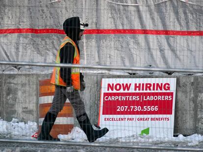 A worker passes a hiring sign at a construction site, Wednesday, Jan. 25, 2023, in Portland, Maine.
