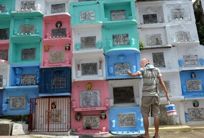 Un trabajador pinta las tumbas en un cementerio de Manila, preparándolas para el día de Todos los Santos.