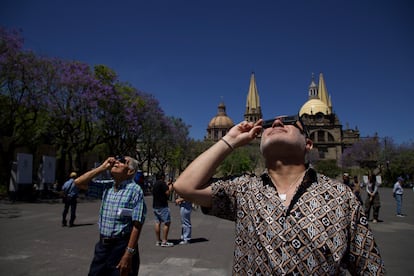 Ciudadanos observan el eclipse afuera de la catedral de Guadalajara (México).
