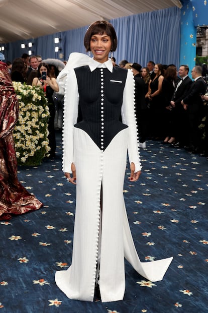 La oscarizada actriz Zoe Saldaña, con un original vestido bicolor de falda de corte sirena y chaqueta militar con lazada a la espalda. Lo firma Thom Browne.