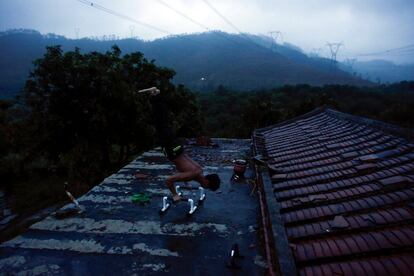 Worker Shi Shenwei demonstrates his training routine on the roof of an old farm house in the village of Huangshan, near Quanzhou, Fujian Province, China, September 28, 2016. REUTERS/Thomas Peter        SEARCH "BRICK CARRIER" FOR THIS STORY. SEARCH "WIDER IMAGE" FOR ALL STORIES. 