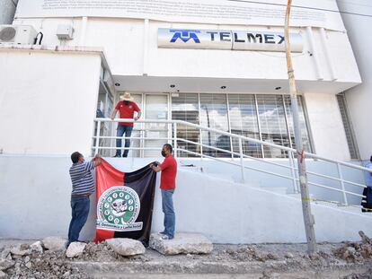 Integrantes del Sindicato de Telefonistas (STRM) de TELMEX colocan banderas en las oficinas de la empresa en Chilpancingo (Estado de Guerrero) al estallar la huelga, el 21 de julio de 2022.