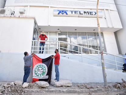 Integrantes del Sindicato de Telefonistas (STRM) de TELMEX colocan banderas en las oficinas de la empresa en Chilpancingo (Estado de Guerrero) al estallar la huelga, el 21 de julio de 2022.