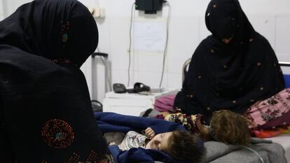 Dos mujeres observan a sus hijos que se encuentran en estado de coma, en el Hospital Boost de Helmand administrado por Médicos Sin Fronteras (MSF) en Kabul, Afganistán. La desnutrición se ha convertido en la peste del país. Al menos 23 millones de sus casi 40 millones de habitantes pasan hambre, con cerca de nueve millones a un paso de la hambruna. Otro millón de niños de menos de cinco años podría morir en los próximos meses por esta causa.