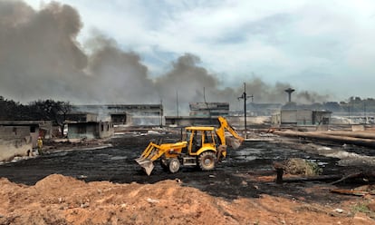 Una volqueta trabaja recogiendo los restos de los incendios en la zona industrial del puerto de Matanzas.