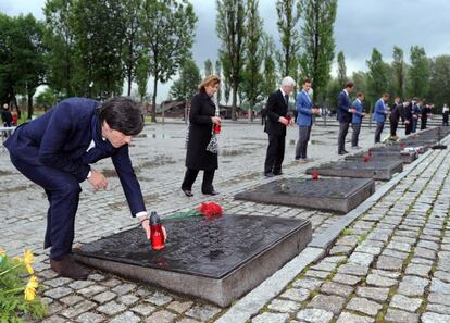 Joachim Loew posa una vela en una de las placas que recuerda a las víctimas