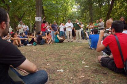 El Nobel Stiglitz, de verde y megáfono en mano, se dirige a la asamblea de los indignados en el parque de El Retiro.