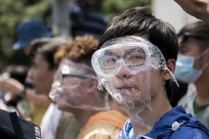 Un manifestate cubierto con gafas y plástico para evitar los efectos del gas pimienta utilizado por los antidisturbios.